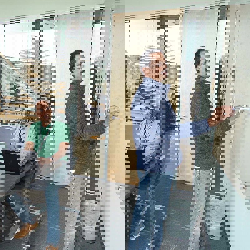 Individuals from IT in a team meeting using a whiteboard for their discussion