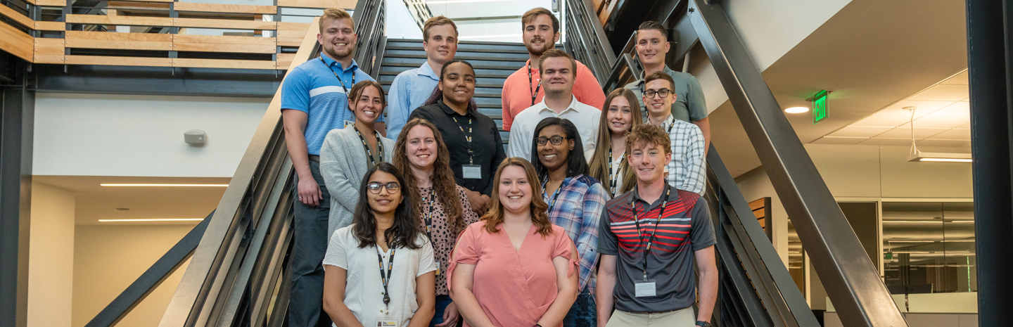 A few members of the summer 2022 interns gather for a photo on the steps at the COB headquarters