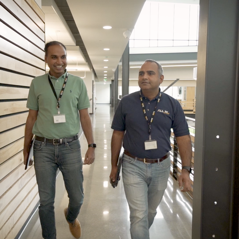 Two individuals walking down a hallway together, chatting at The Andersons headquarters