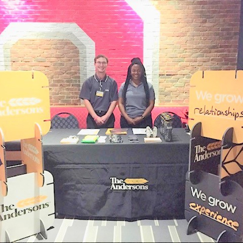 Two recruiters at a booth for The Andersons