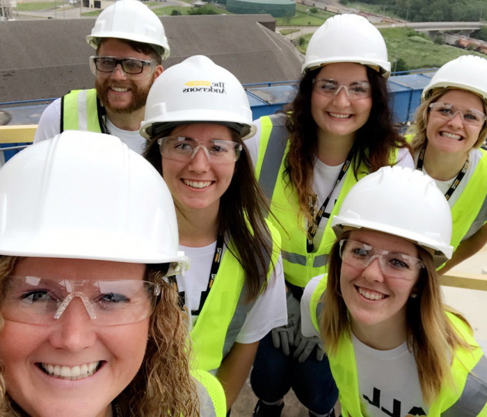 Individuals from The Andersons internship program pose for photo in hard hats at an operations location
