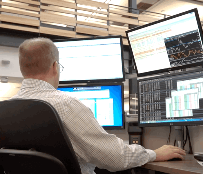 Trader working at their desk with multiple monitors