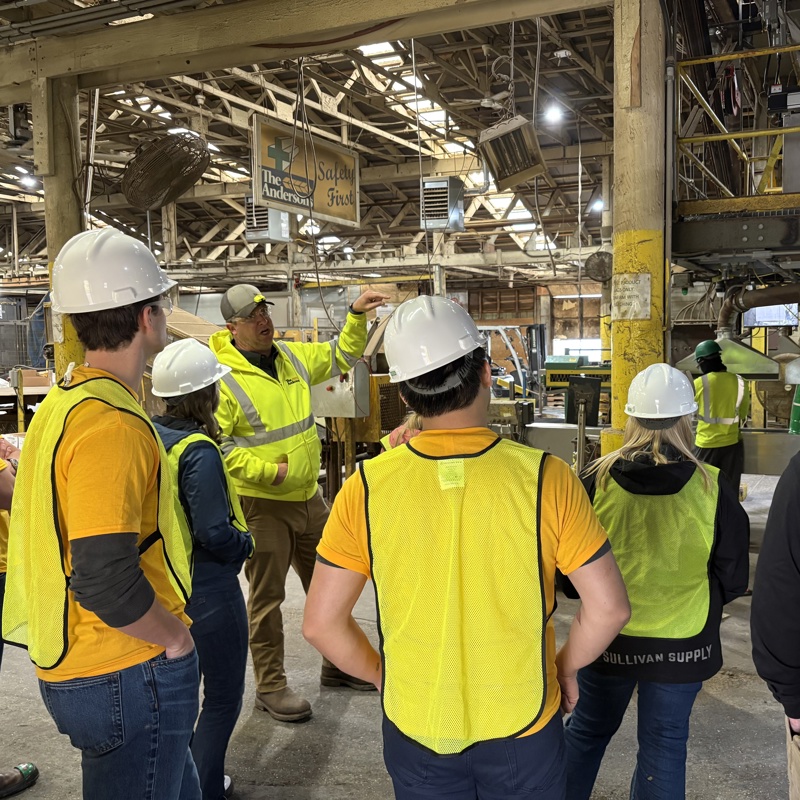 Group of interns wearing PPE inside of a plant
