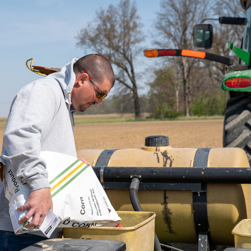 Man pouring corn seed into planter