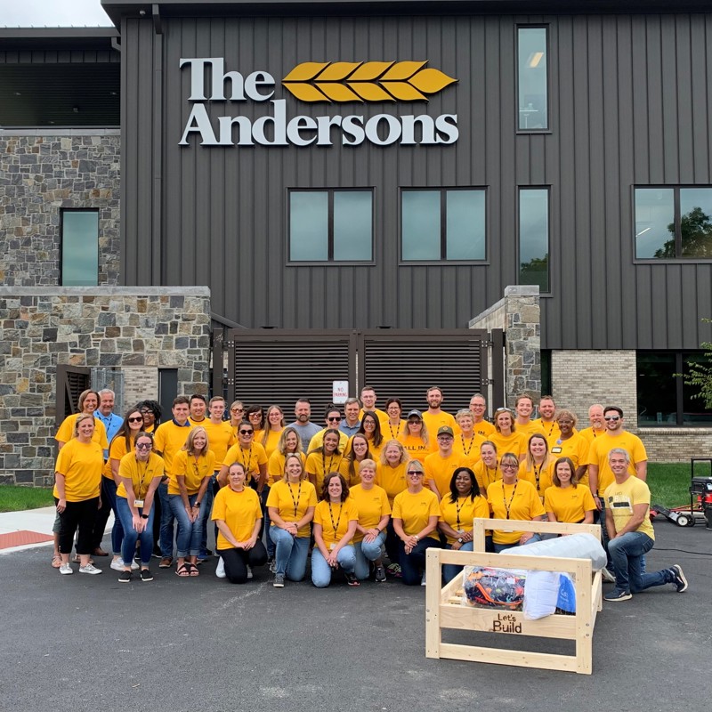 Employees with yellow shirts in front of office building