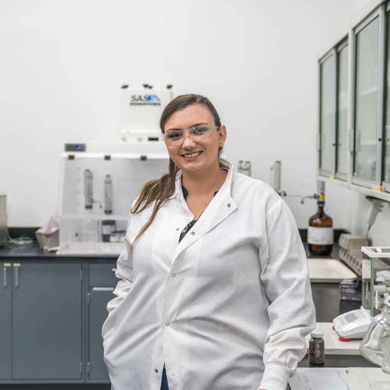 Individual wearing PPE standing in a lab