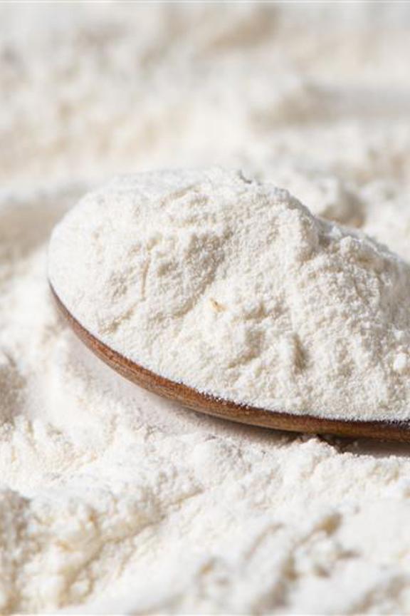 Spoonful of flour resting on top of flour